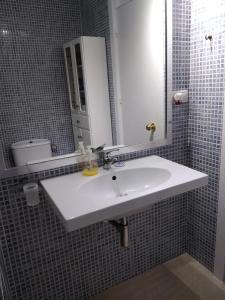 uma casa de banho com um lavatório branco e um espelho. em De la Montaña al Mar em Almeria