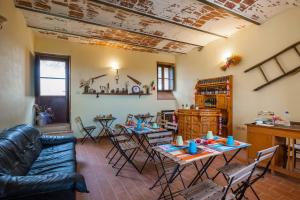 uma sala de estar com um sofá, mesas e cadeiras em Perugia Farmhouse em Perugia