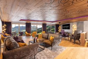 4*S Galtenberg Resort في ألباخ: غرفة معيشة مع أريكة وكراسي
