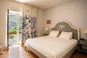 a bedroom with a bed and a large window at Quinta Dona Matilde in Peso da Régua