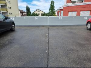 a car parked in a parking lot next to a fence at Bodensee Loft - 116 m² Traumwohnung in Uhldingen-Mühlhofen