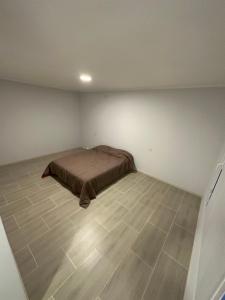 Un dormitorio con una cama y suelo de baldosas. en Casa barrio cerrado Las Lomas, en Monte Hermoso