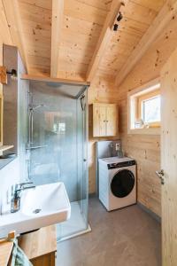 a bathroom with a sink and a washing machine at Holznest - dein Urlaub im gemütlichen Holzhaus in Schönau am Königssee +17 photos