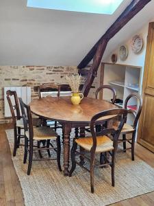 een eettafel met stoelen en een vaas erop bij Sous les toits de Cahors in Cahors