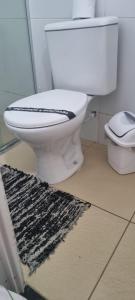 a bathroom with a toilet and a rug on the floor at Pousada Pitanga in Maceió