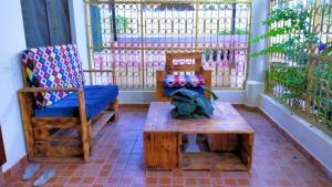 a porch with two chairs and a table and a bench at Lux Suites Mtwapa Holiday Home in Mtwapa