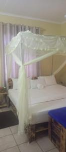 a white bed with a canopy in a room at Lux Suites Mtwapa Holiday Home in Mtwapa