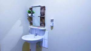 a white bathroom with a sink and a mirror at Lux Suites Mtwapa Holiday Home in Mtwapa +14 photos