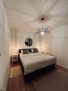een slaapkamer met een groot bed en een kroonluchter bij Apartments Jabuka in Tribunj