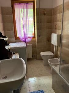 bagno con lavandino, servizi igienici e finestra di Alloggio MARIPOSA a Borgo San Dalmazzo