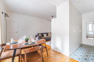 sala de estar con mesa, sillas y sofá en Cozy flat Paris centre, en París