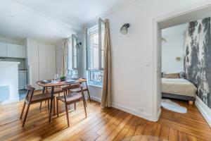 a dining room with a table and chairs and a bedroom at Cozy flat Paris centre in Paris