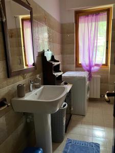 bagno con lavandino e specchio di Alloggio MARIPOSA a Borgo San Dalmazzo