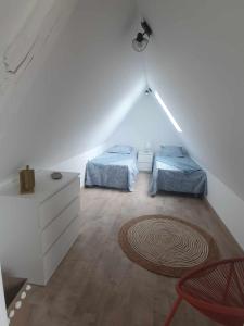 - une chambre mansardée avec 2 lits et un tapis dans l'établissement Les terrasses de Dordogne, à Argentat