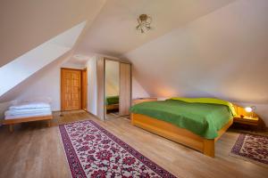 Dormitorio con cama y espejo en el ático en Guest House Mengsdorf, en Mengusovce