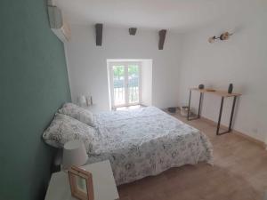 - une chambre blanche avec un lit et une fenêtre dans l'établissement Les terrasses de Dordogne, à Argentat