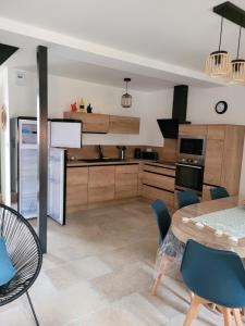 a kitchen with a table and chairs and a dining room at Les terrasses de Dordogne in Argentat +14 photos