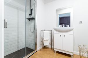 a bathroom with a sink and a shower at Victus Apartamenty Playa&Relax in Sopot