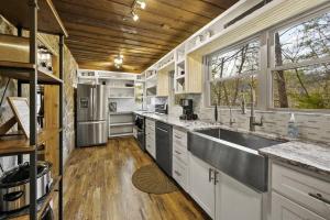 a large kitchen with a sink and a refrigerator at Secluded Cabin / Stunning Mtn View / Paved Drive in Sevierville