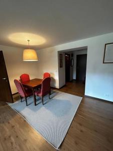 ein Esszimmer mit einem Tisch und Stühlen auf einem Teppich in der Unterkunft [Campiglio] Appartamento Cristallo in Madonna di Campiglio