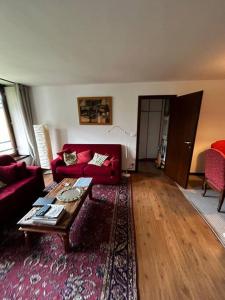 ein Wohnzimmer mit einem roten Sofa und einem Couchtisch in der Unterkunft [Campiglio] Appartamento Cristallo in Madonna di Campiglio