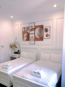 2 Betten in einem Schlafzimmer mit Bildern an der Wand in der Unterkunft Amy Hotel & Apart' Hue in Hue + 24 Fotos