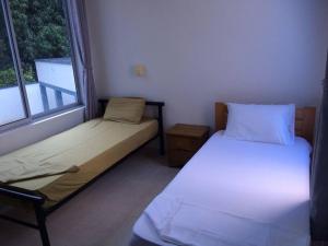 two beds in a small room with two windows at Linda Casa de Descanso in Nilo +19 photos