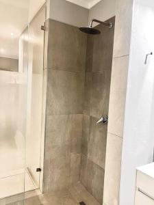um chuveiro com uma porta de vidro na casa de banho em Apartments at Brooklyn/Waterkloof em Pretoria