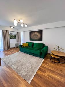 a living room with a green couch and a table at Alegria Avantgarden Brasov in Braşov