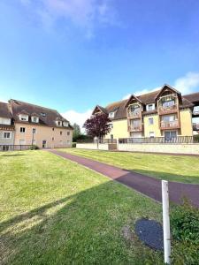 a large building with a walkway in front of a yard at 7mn de Deauville Jardin Wifi Box TV in Saint-Arnoult +8 photos