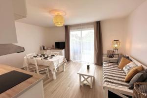 a living room with a couch and a table at 7mn de Deauville Jardin Wifi Box TV in Saint-Arnoult