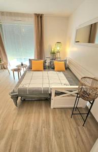 a room with a bed and a chair in it at 7mn de Deauville Jardin Wifi Box TV in Saint-Arnoult +6 photos