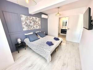 une chambre avec un lit avec des oreillers bleus dessus dans l'établissement Oasis de Thau, à Balaruc-les-Bains