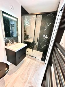 une salle de bain avec un lavabo et une douche en verre dans l'établissement Oasis de Thau, à Balaruc-les-Bains 10 autres photos
