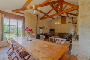 een eetkamer met een grote houten tafel en stoelen bij Côté Four in Monflanquin