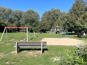 a park with a bench and two swings at Urlauberdorf Haus 63d in Boltenhagen