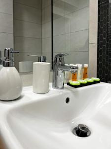 a white bathroom sink with a mirror and a sink at Alegria Avantgarden Brasov in Braşov