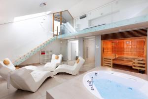 a living room with a tub and a staircase at OREA Hotel Arigone Olomouc in Olomouc
