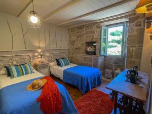sypialnia z dwoma łóżkami i oknem w obiekcie Cas do Mestre Casa rural con Encanto w mieście Pontevedra
