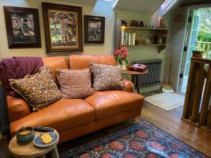 a brown leather couch in a living room at The Barley Mill in Bude