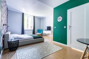 a bedroom with a bed and a green wall at Victus Apartamenty Playa&Relax in Sopot