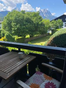 uma mesa e cadeira numa varanda com vista para uma montanha em Bergliebe em Garmisch-Partenkirchen