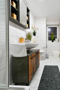 ein Bad mit einem Waschbecken und einem WC in der Unterkunft Exklusives-City-Apartment mit gratis Tiefgarage, Balkon, Waschtrockner, Netflix in Cottbus
