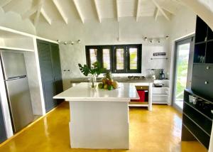 a kitchen with a white island with fruits on it at Spectacular Cozy Sea View Staffed Villa in Las Terrenas
