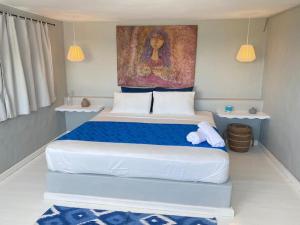 a bedroom with a large white bed with blue sheets at Spectacular Cozy Sea View Staffed Villa in Las Terrenas