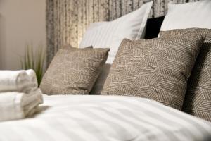 łóżko z białą pościelą i poduszkami w obiekcie Exklusives-City-Apartment mit gratis Tiefgarage, Balkon, Waschtrockner, Netflix w mieście Chociebuż
