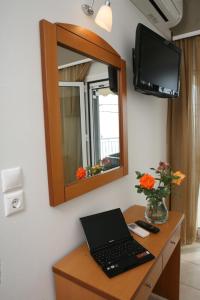 a laptop on a desk in a room with a mirror at Atlon Hotel in Paralia Vrachou