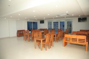 a dining room with wooden tables and chairs at Thiên Tài Hotel in Ho Chi Minh City