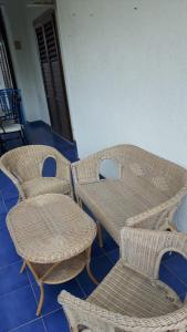 a group of wicker chairs and tables in a room at Casa Rea in Montepaone Lido