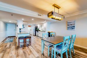 a kitchen and dining room with a table and chairs at Surf Dweller 203 in Fort Walton Beach